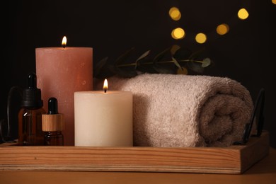 Photo of Beautiful composition with different spa products on wooden table against blurred lights, closeup