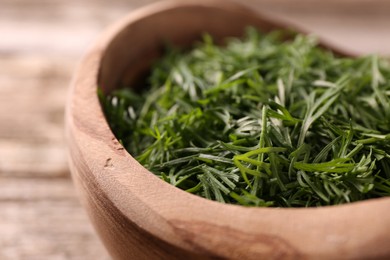 Photo of Fresh cut dill in bowl on table, closeup