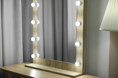 Photo of Beautiful mirror with light bulbs in makeup room