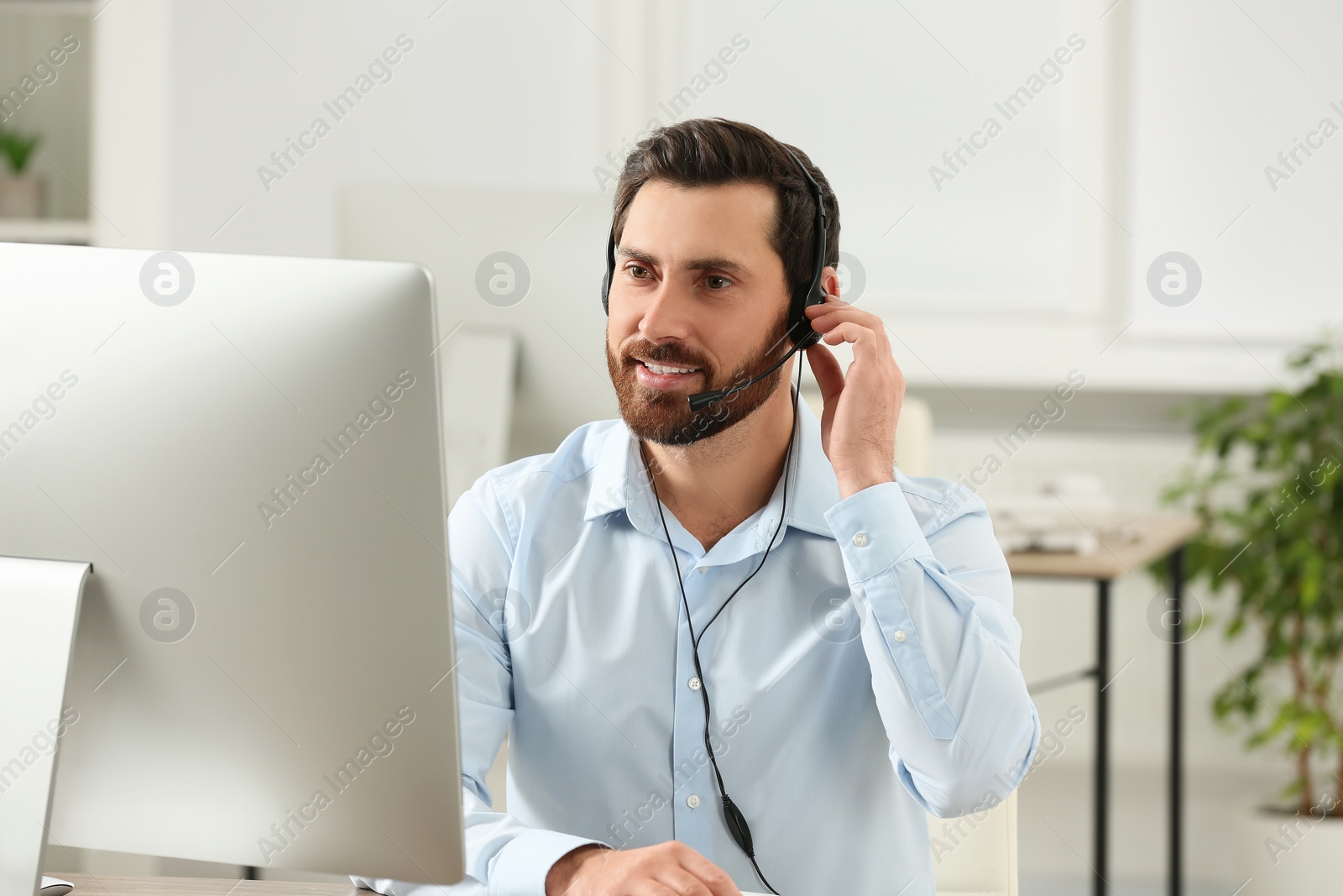 Photo of Hotline operator with headset working in office