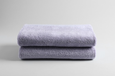 Stack of fresh fluffy towels on grey background