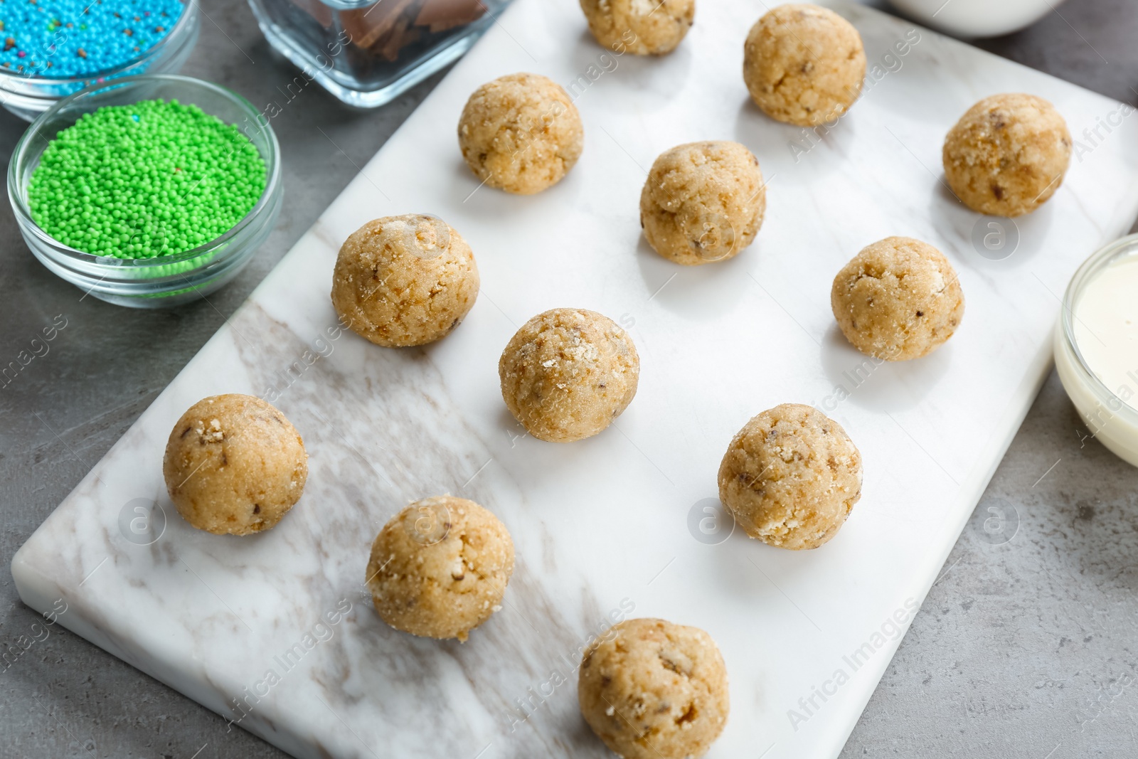 Photo of Board with half made cake pops on grey background, closeup