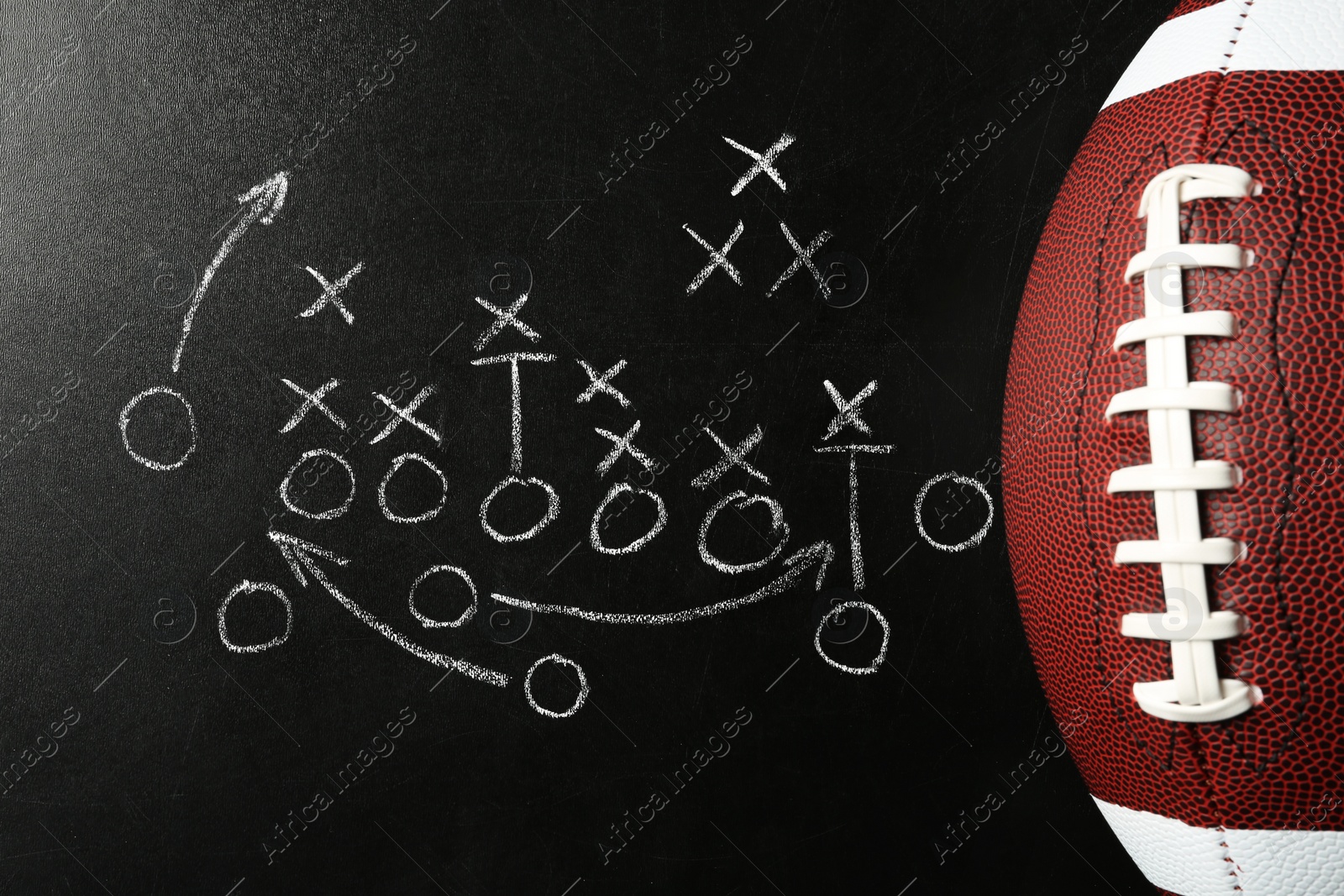 Photo of Chalkboard with football game scheme and rugby ball, top view