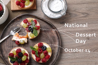 National Dessert Day, October 14. Delicious tartlets with fresh berries on wooden table, flat lay