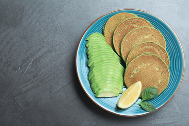 Photo of Tasty spinach pancakes served on grey table, top view. Space for text