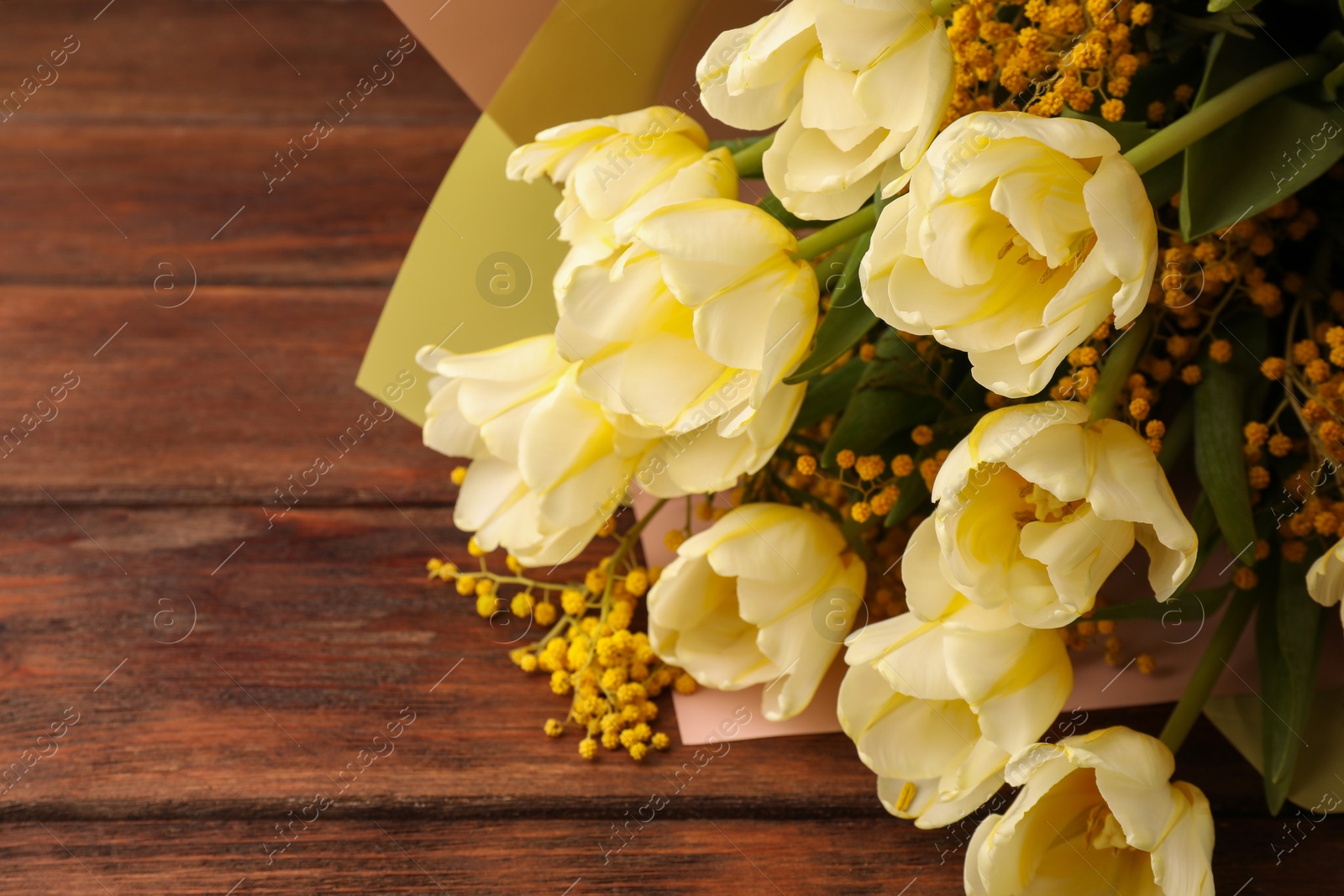 Photo of Bouquet with beautiful tulips and mimosa flowers on wooden table. Space for text