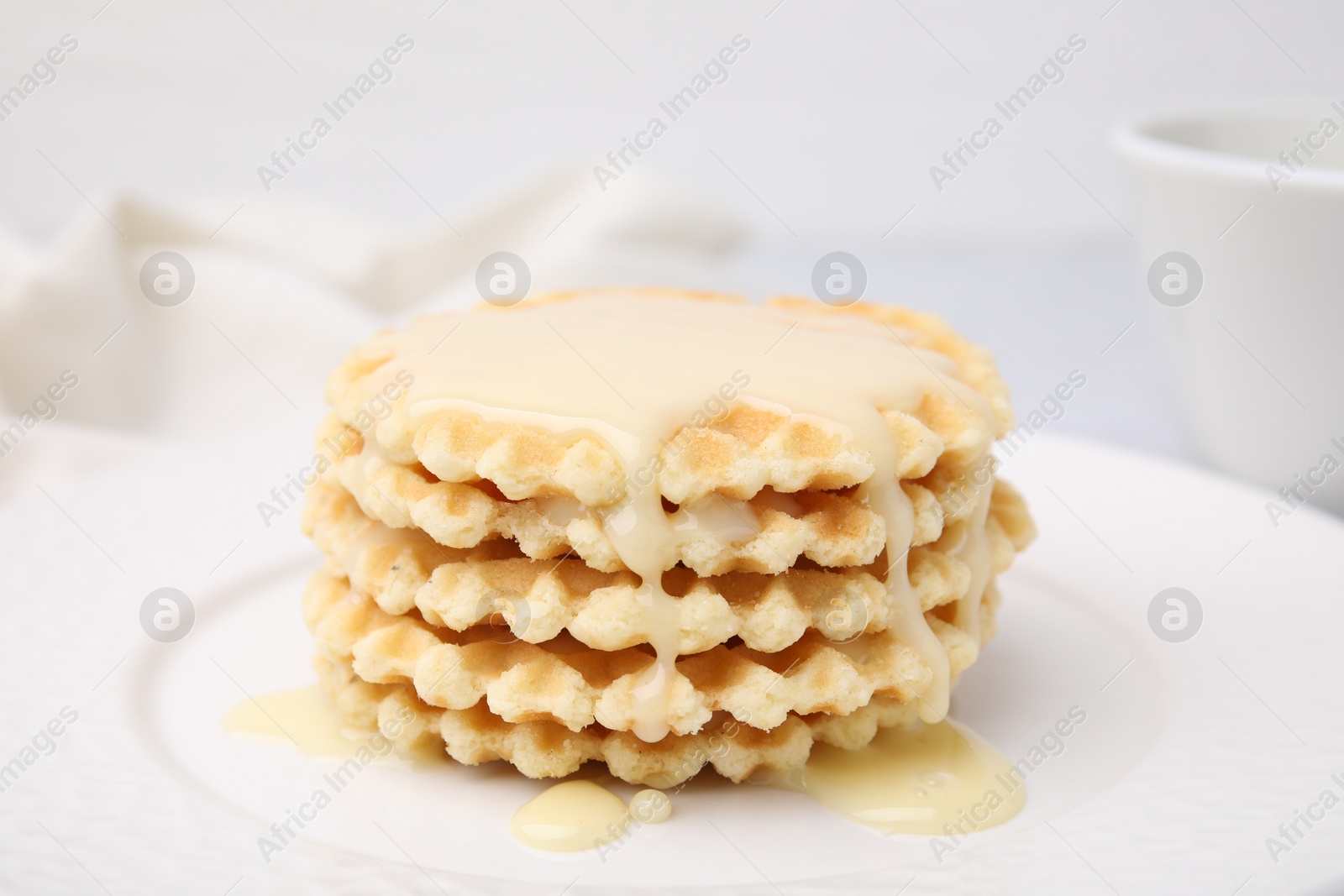 Tasty waffles with condensed milk on plate, closeup Photo of Tasty waffles with condensed milk on plate, closeup