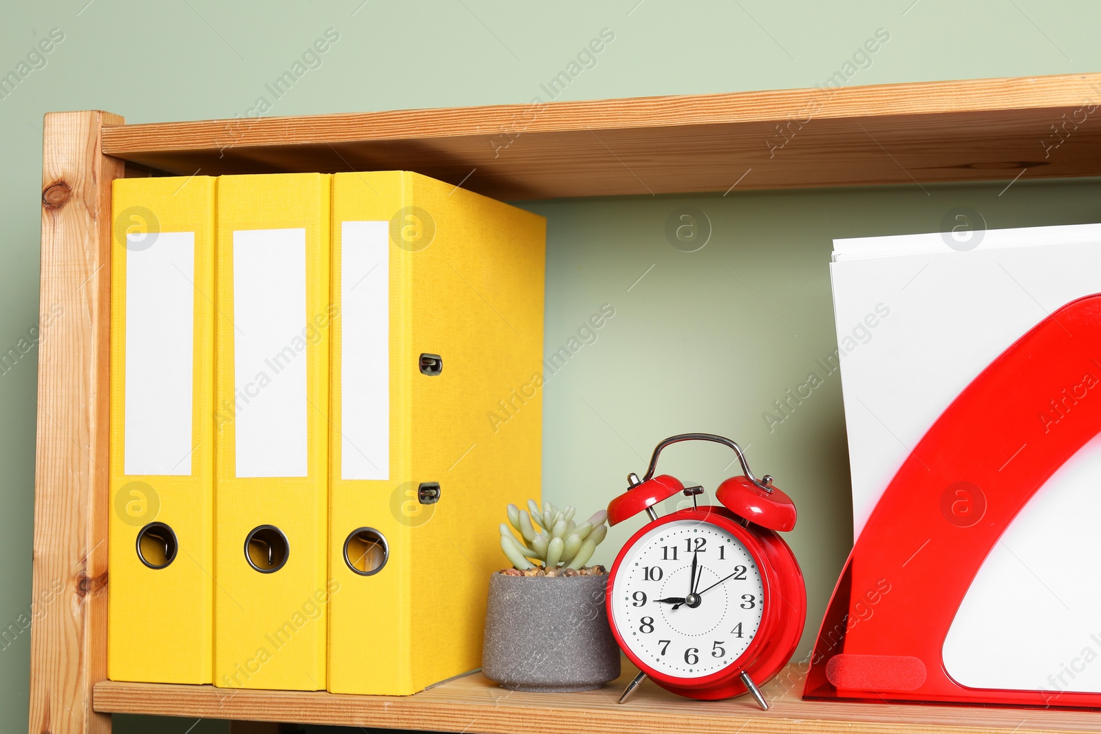 Photo of Colorful binder office folders and stationery on shelving unit indoors