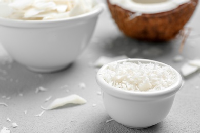 Photo of Fresh coconut flakes in bowl on light background