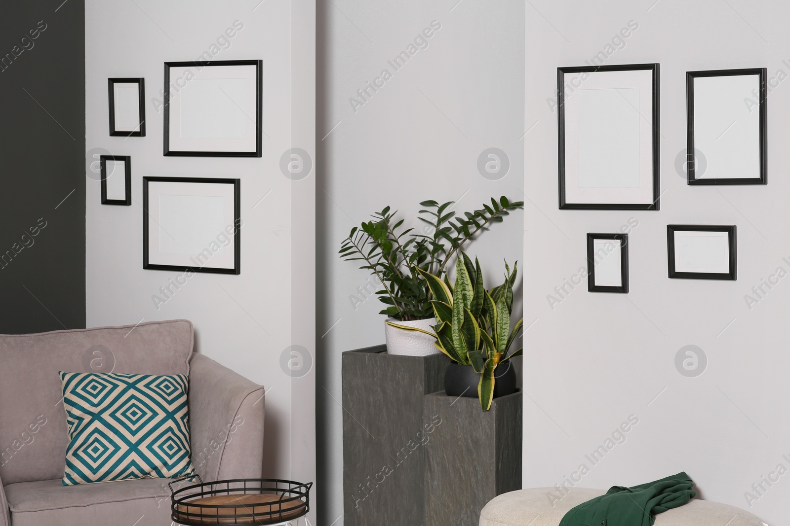 Photo of Empty frames hanging on white wall in stylish room