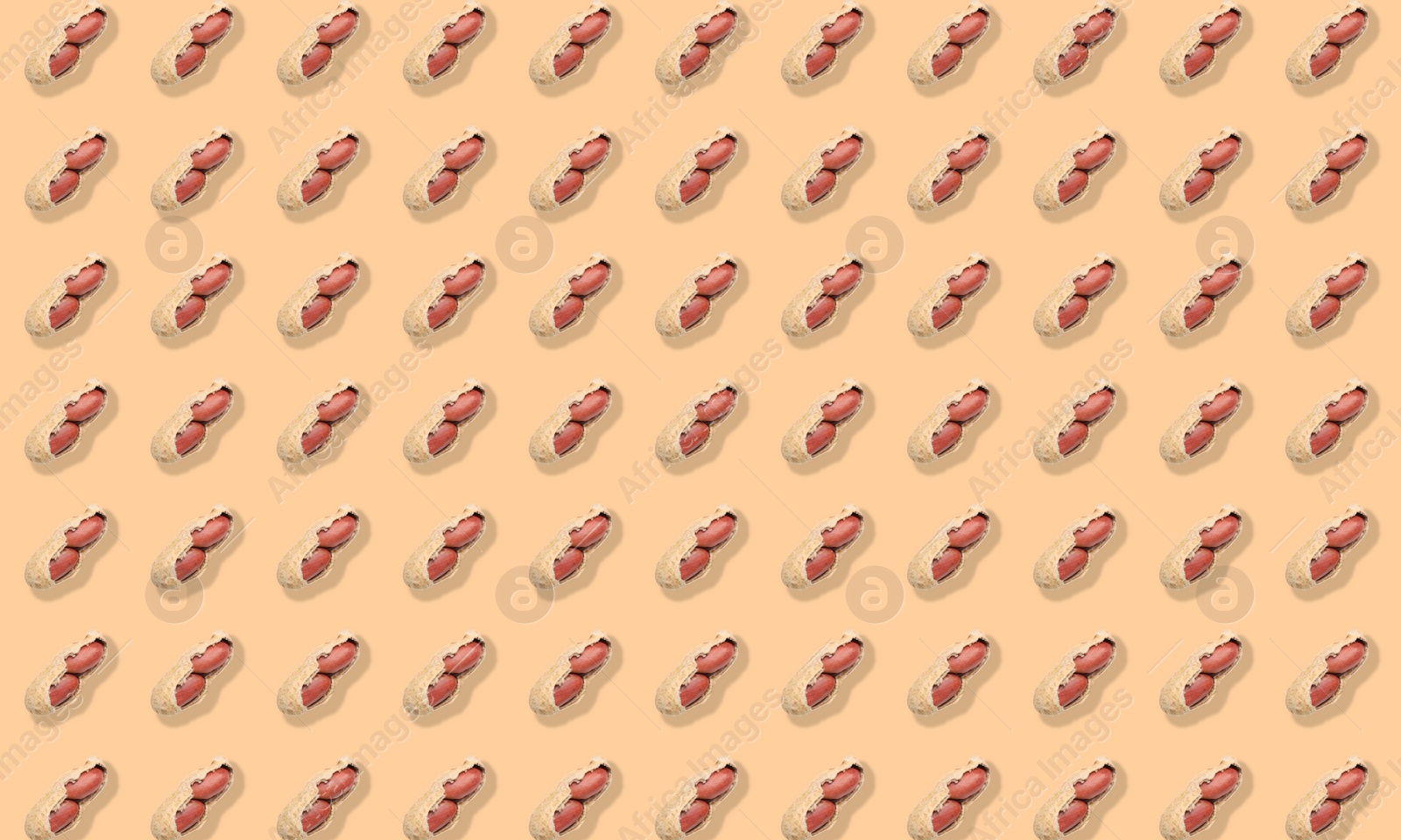 Image of Pattern of unpeeled peanuts on beige background