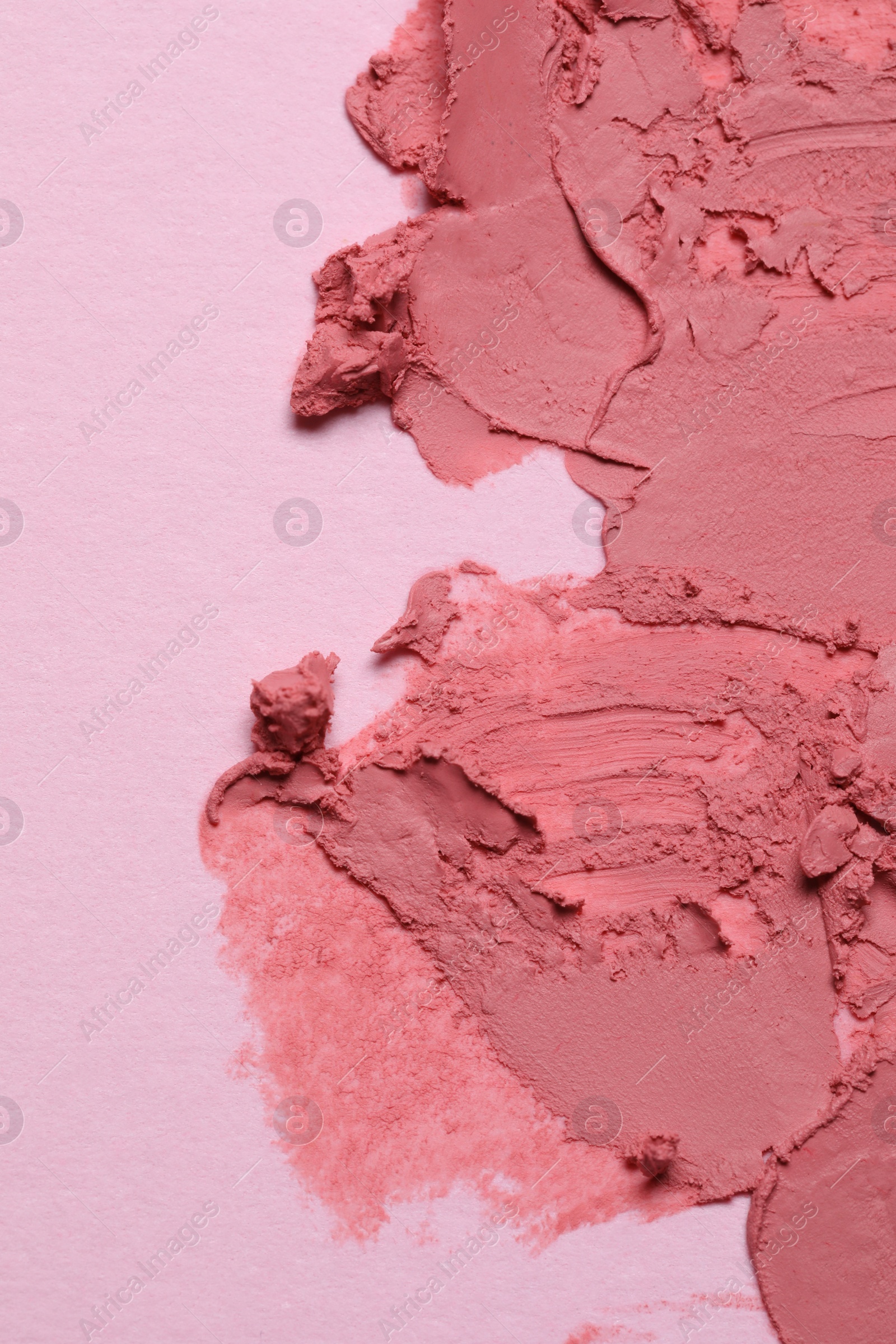 Photo of Smears of beautiful lipstick on pink background, top view