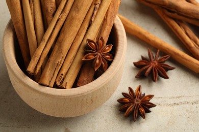 Photo of Bowl with cinnamon sticks and star anise on light table, closeup