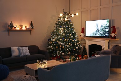 Cozy living room interior with beautiful Christmas tree near fireplace