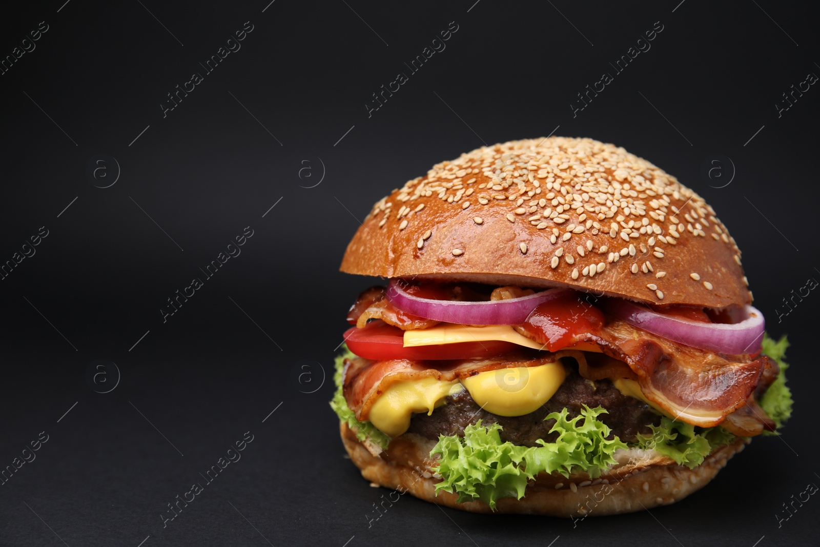 Photo of Delicious burger with bacon, patty and vegetables on black background. Space for text