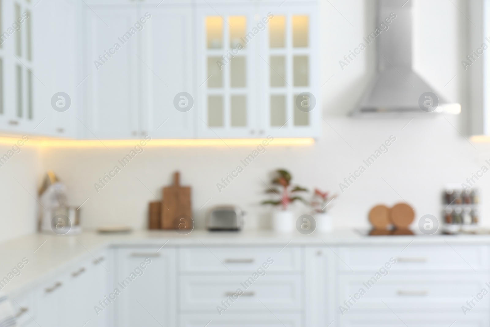 Photo of Blurred view of modern kitchen with white furniture