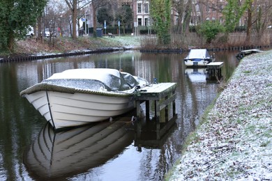 Photo of Picturesque view of water canal with moored boats on winter day