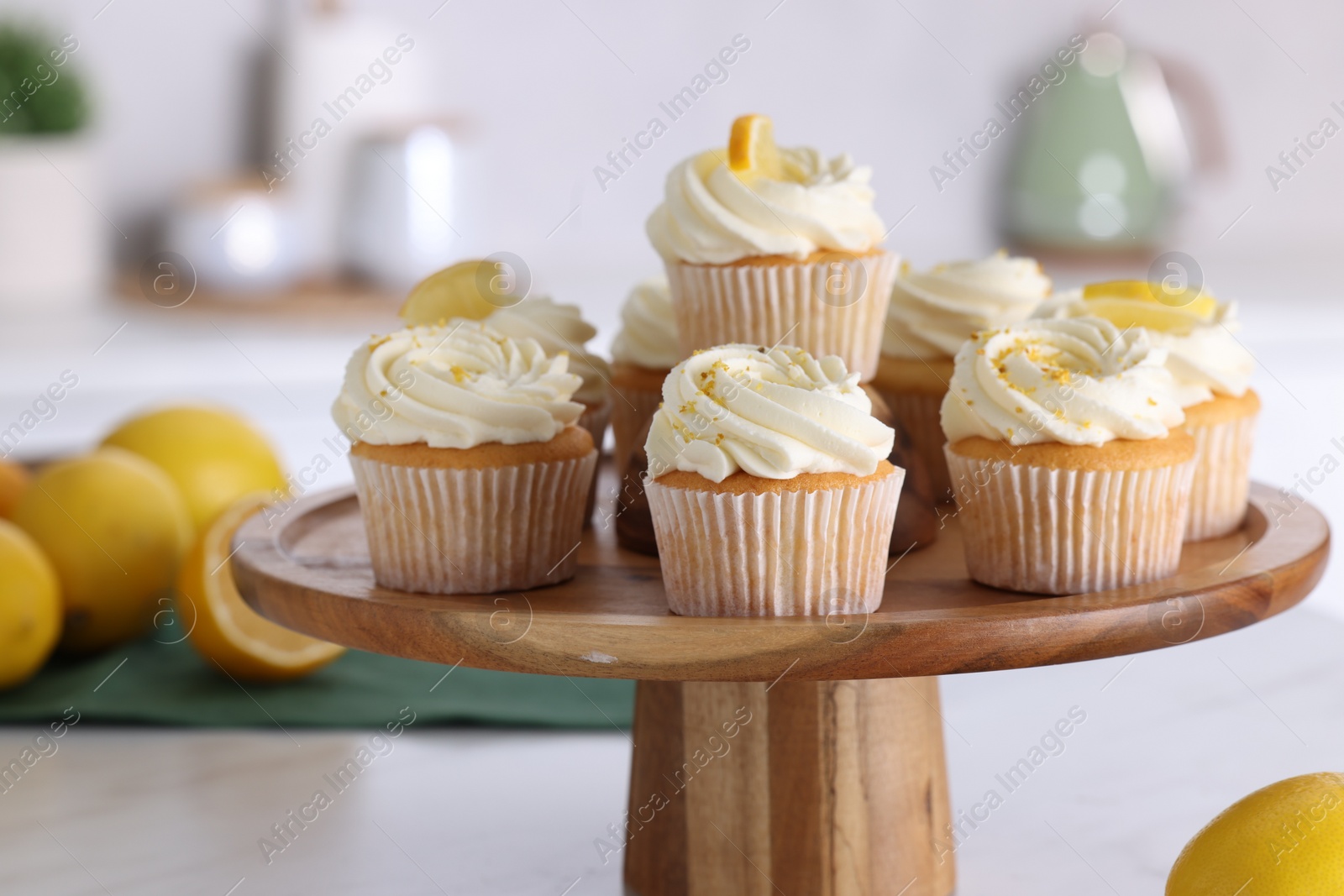 Photo of Delicious lemon cupcakes with white cream on table, closeup