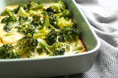 Photo of Tasty broccoli casserole in baking dish on table, closeup