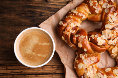 Delicious pastries and coffee on wooden table, flat lay