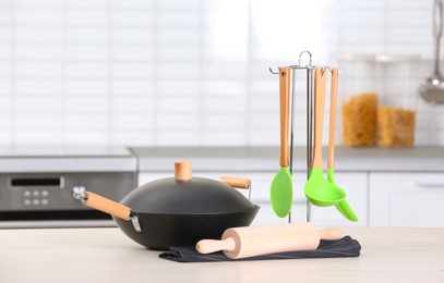 Photo of Set of clean cookware and utensils on table in kitchen