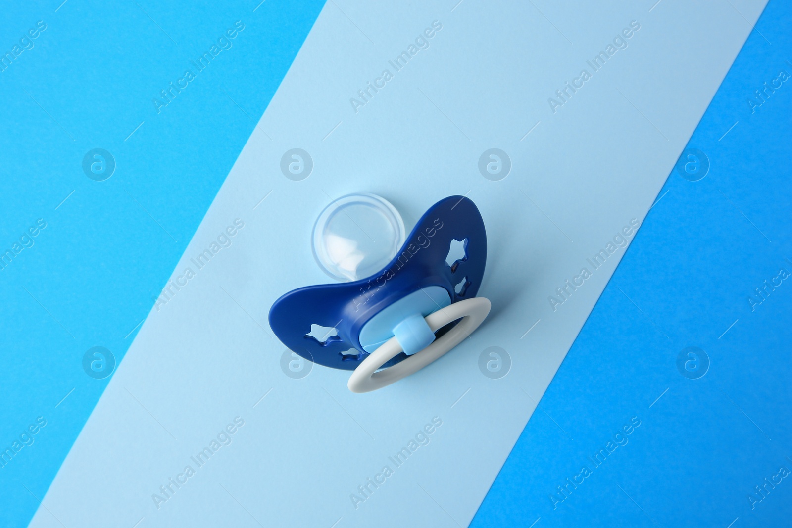 Photo of Baby pacifier on color background, top view