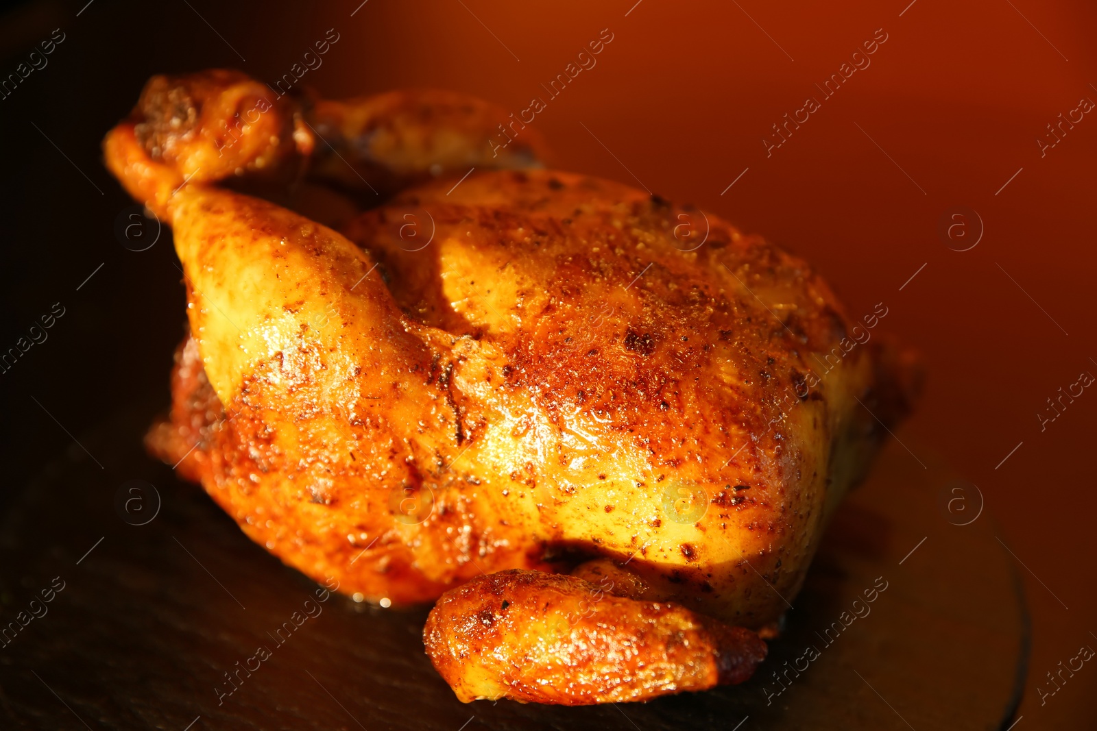 Photo of Delicious grilled whole chicken on black table