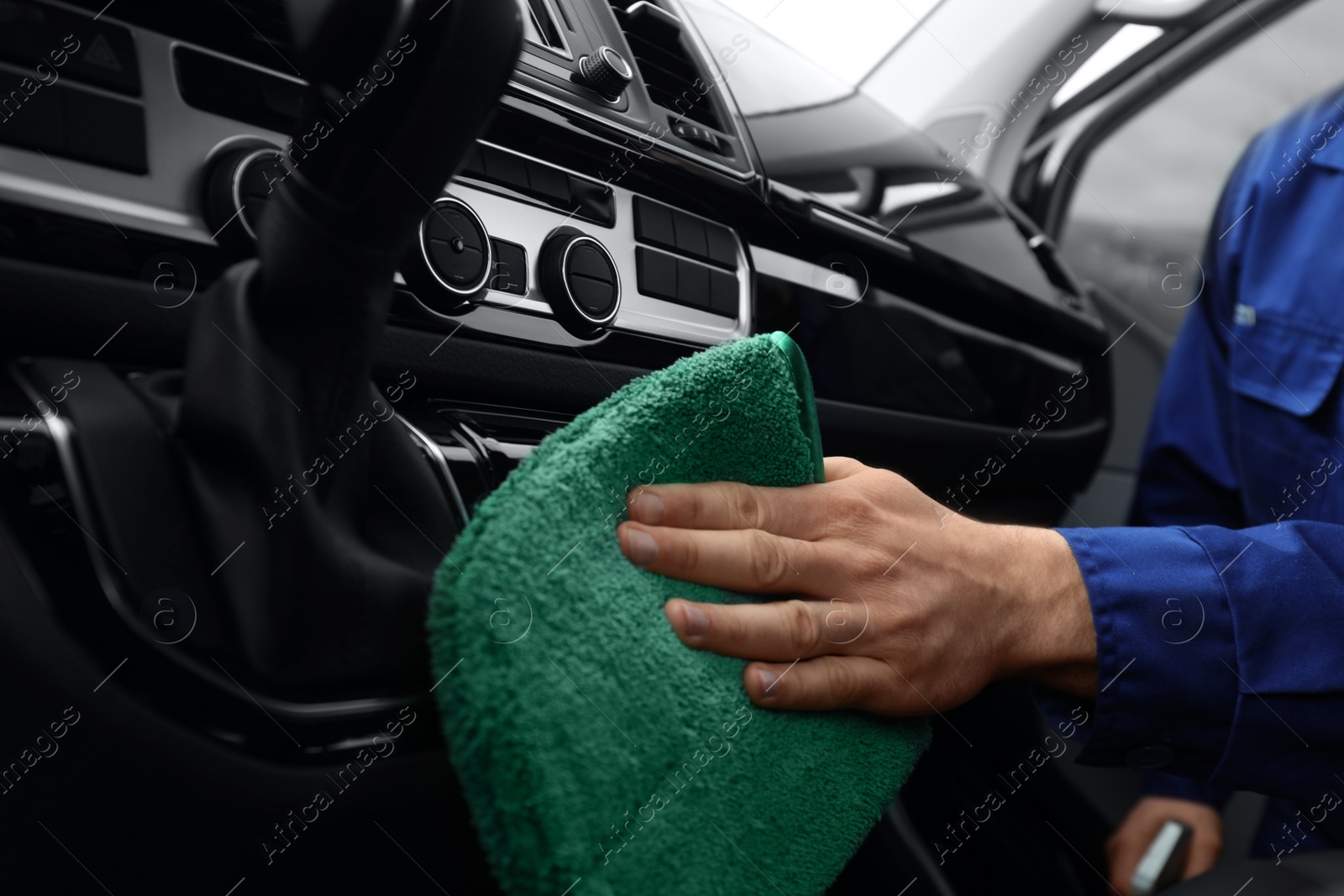 Photo of Car wash worker cleaning automobile interior, closeup