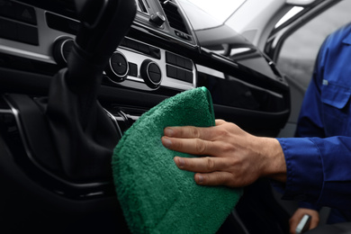 Photo of Car wash worker cleaning automobile interior, closeup
