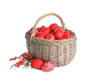 Wicker basket with painted red Easter eggs on white background