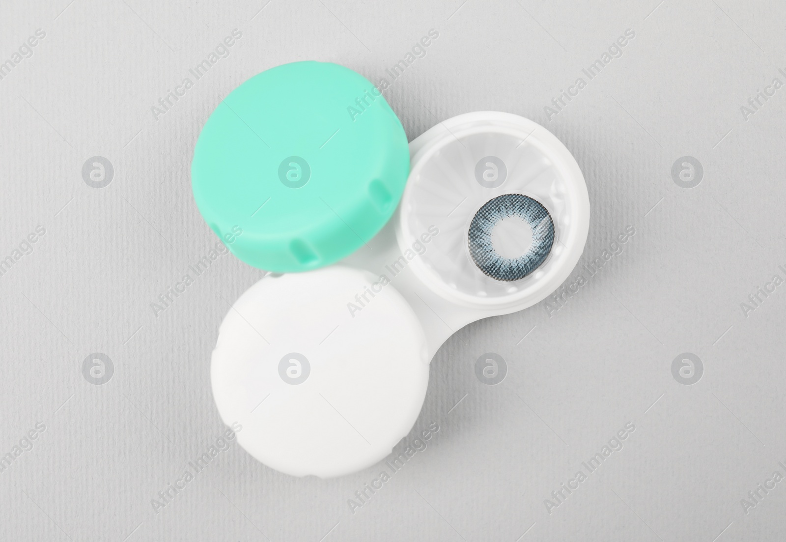 Photo of Case with blue contact lenses on light grey background, top view