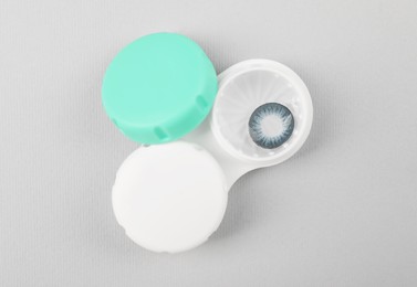 Photo of Case with blue contact lenses on light grey background, top view