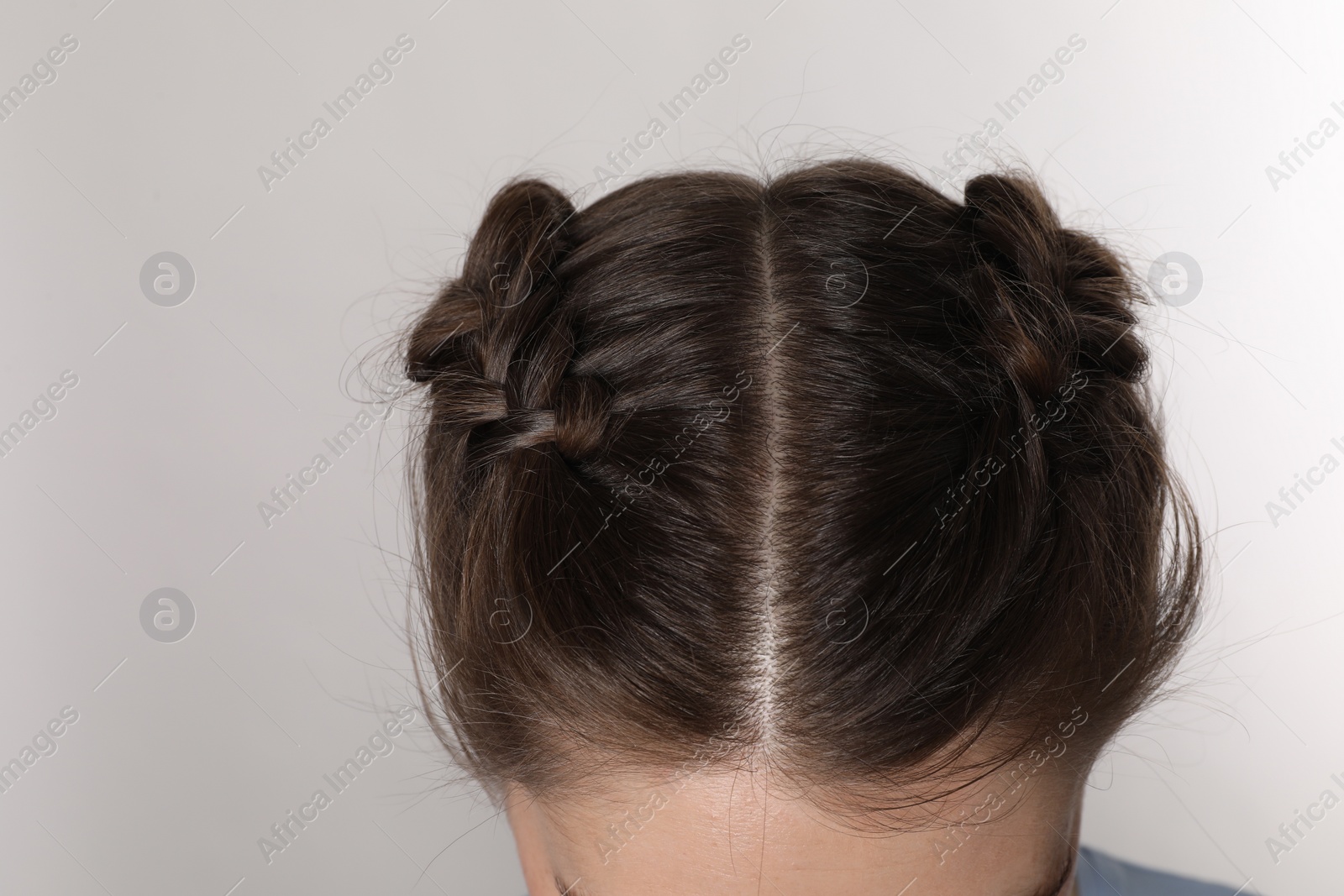 Photo of Woman with braided hair on light grey background, closeup