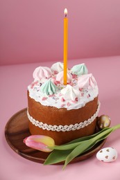 Photo of Traditional Easter cake with meringues, candle, decorated eggs and tulip on pink background