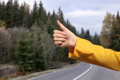 Woman catching car on road, closeup. Hitchhiking trip