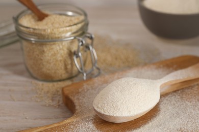 Photo of Spoon with quinoa flour on wooden table, closeup. Space for text