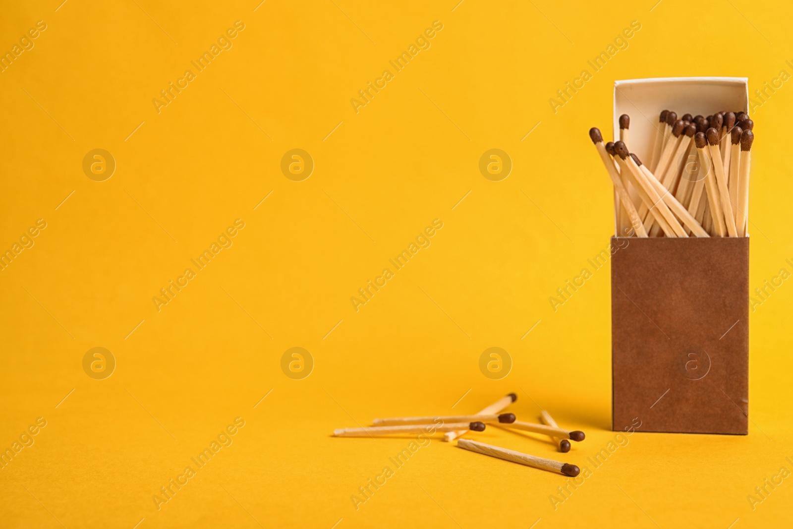 Photo of Cardboard box with matches on color background. Space for text