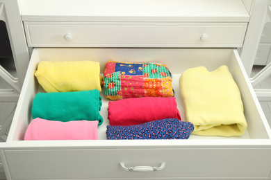 Photo of Folded clothes in open drawer. Apparel storage