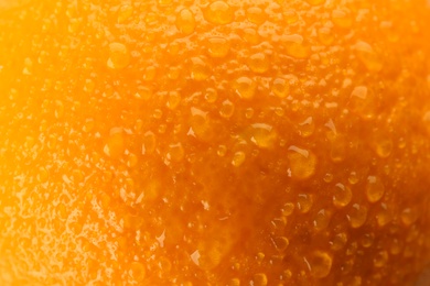 Photo of Delicious unpeeled orange with water drops as background, closeup