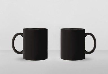 Black ceramic mugs on white background. Mockup for design