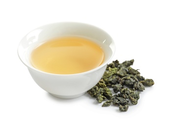 Cup of Tie Guan Yin oolong and tea leaves on white background