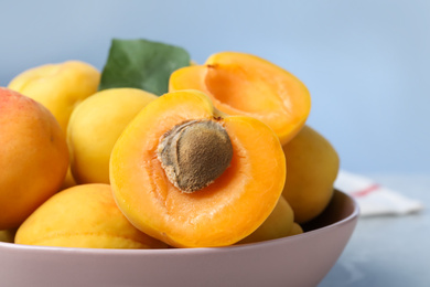 Photo of Delicious fresh ripe apricots on blue background, closeup