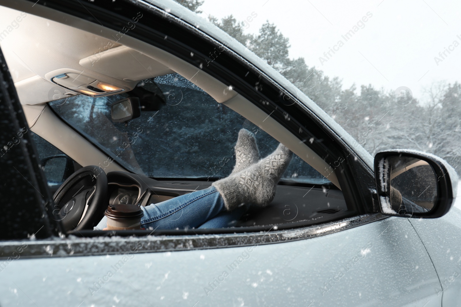 Photo of Young woman in warm socks resting inside car, closeup