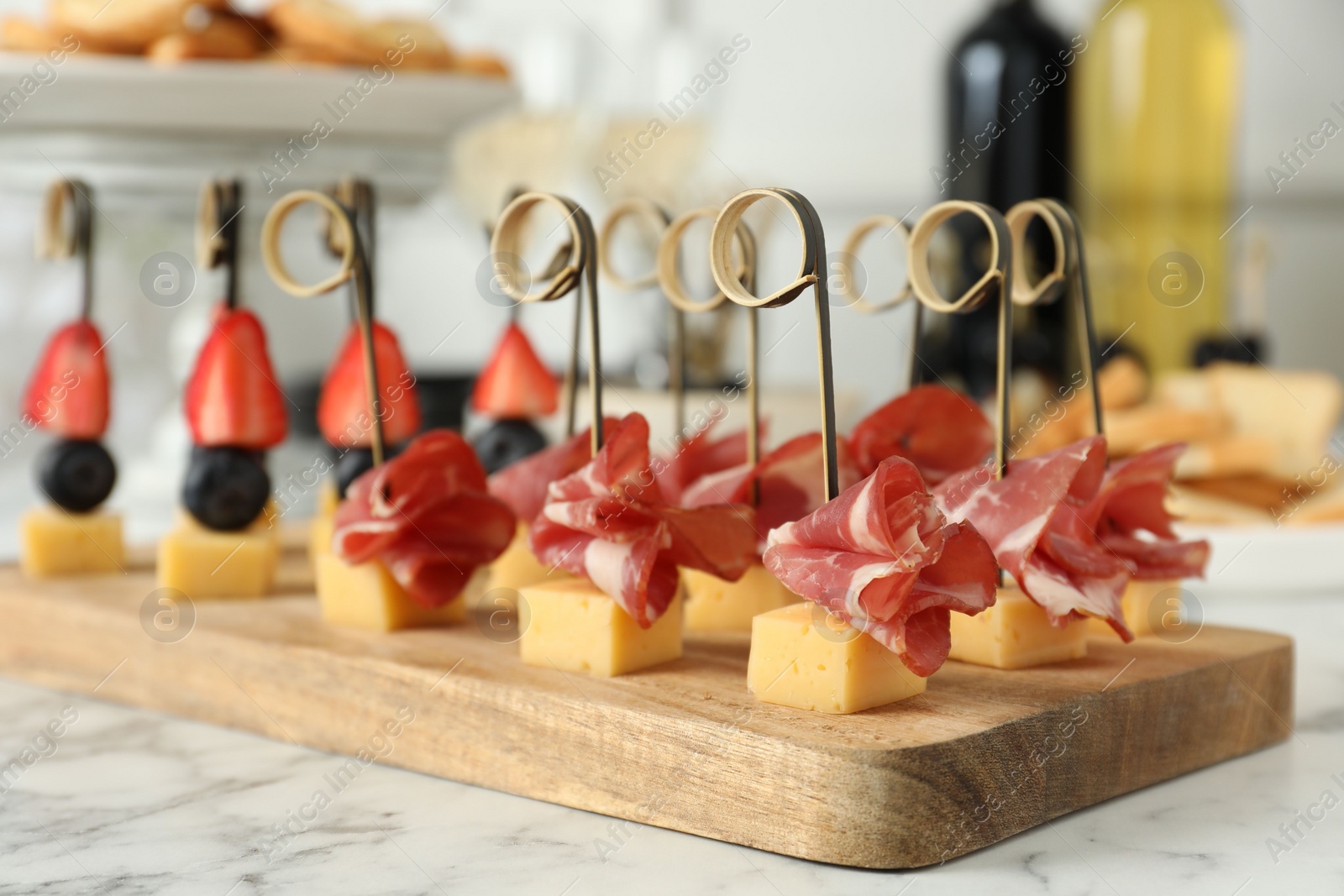 Photo of Different tasty canapes on white marble table, closeup