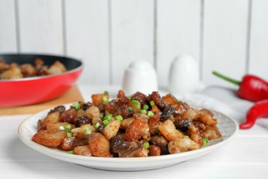 Tasty fried cracklings on white wooden table. Cooked pork lard