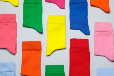 Photo of Different colorful socks on grey background, flat lay