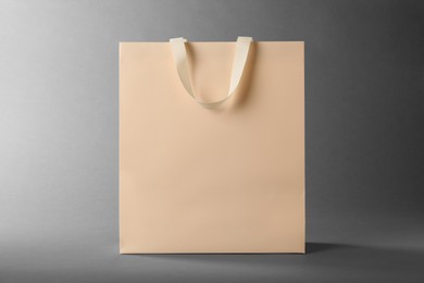 Photo of One paper bag on grey background. Mockup for design