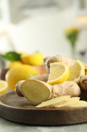 Photo of Fresh lemon and ginger on grey table, closeup. Space for text