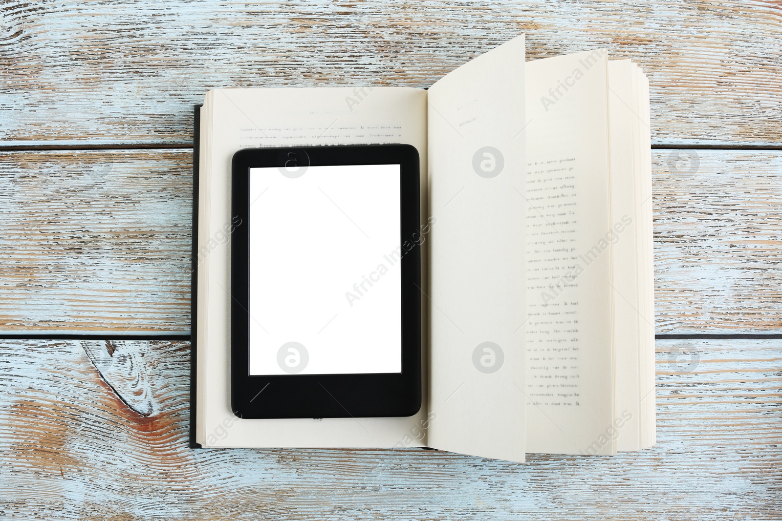 Photo of Portable e-book reader and hardcover book on wooden rustic table, top view