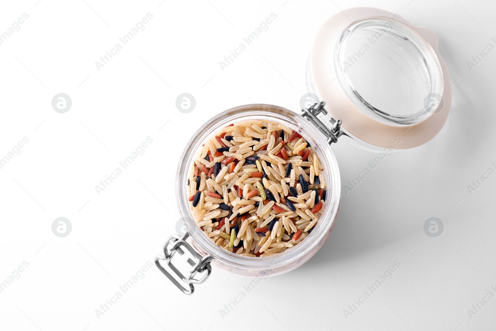 Photo of Mix of brown rice in jar isolated on white, top view